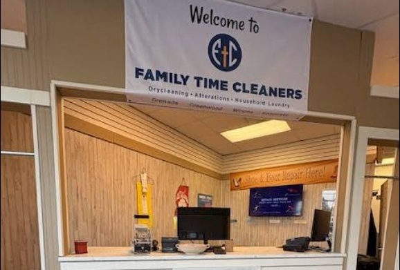 A dry cleaning shop counter with computers and a 